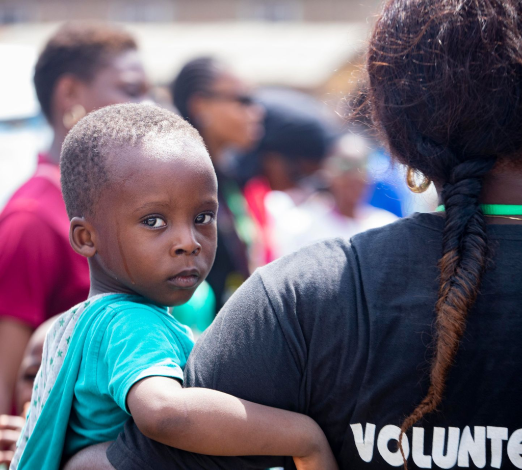A volunteer helping a child at a community outreach event. — get involved Crime Stoppers PA