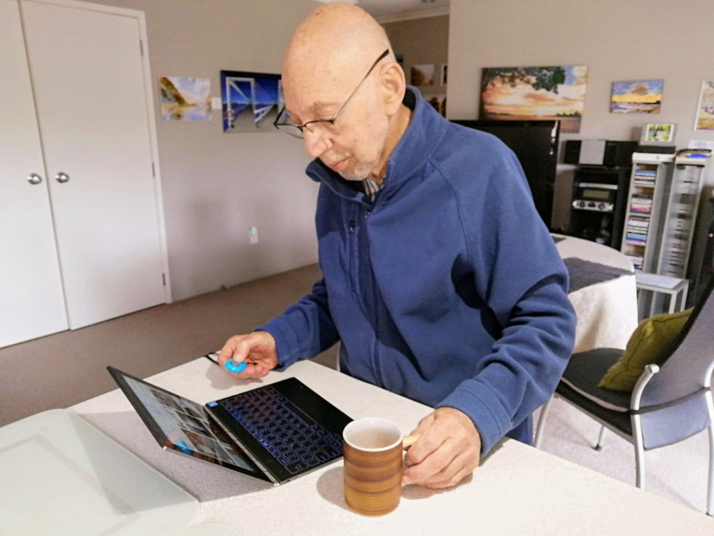 A photo of a senior using a computer with a cybersecurity app open. — senior scam prevention