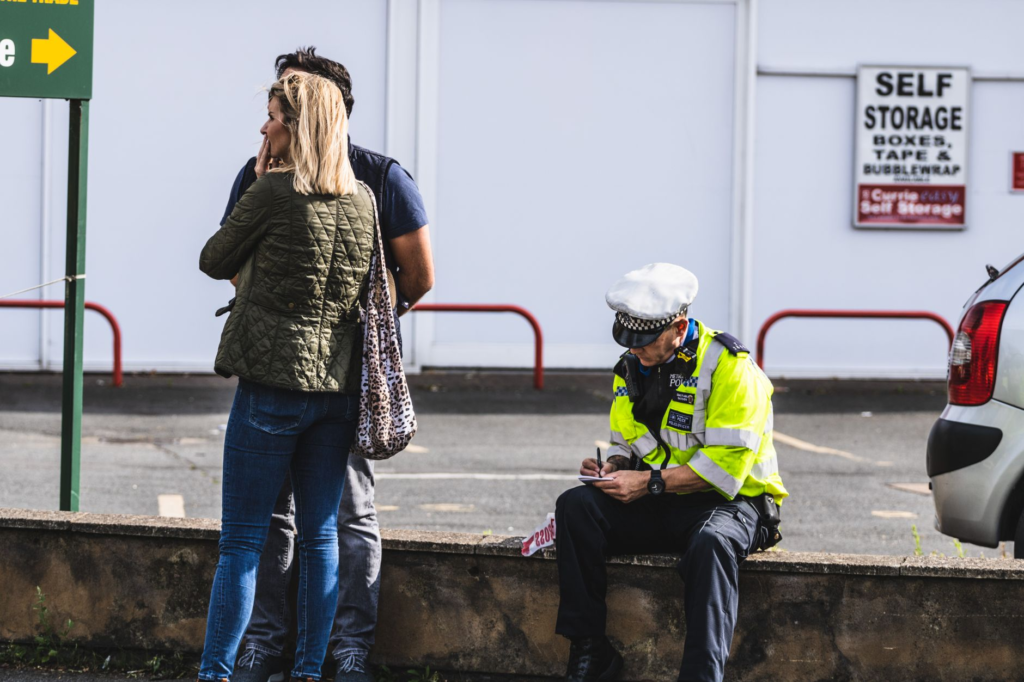 An image of a police officer receiving a crime tip from a community member. This highlights how to report a crime PA effectively.