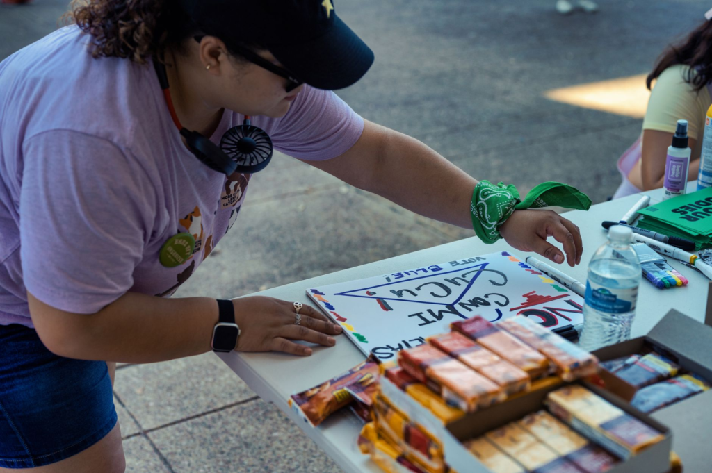 Image of a volunteer participating in a community event with a Crime Stoppers banner. — become a PA Crime Stoppers volun…