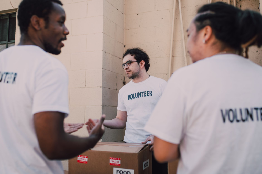 A group of volunteers working together on a community project with the PA Crime Stoppers logo in the background. — volun…
